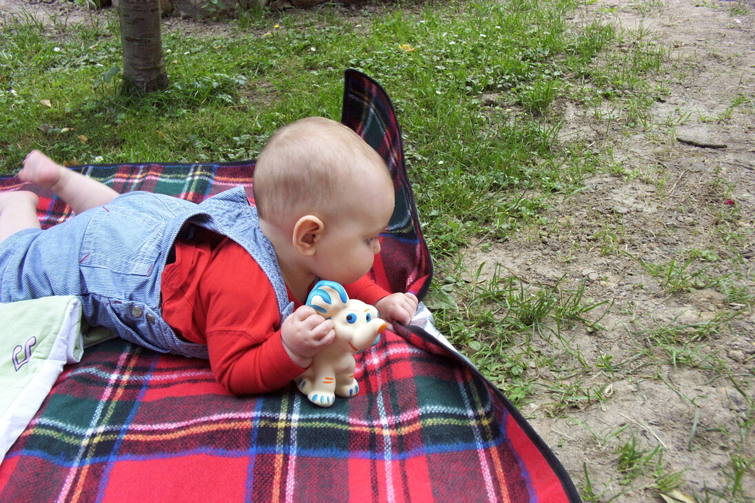 Das Bild zeigt ein Baby auf einer Decke.