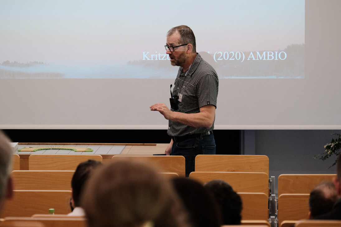 Herr Professor Doktor Laudon läuft vor der Leinwand und gestikuliert.