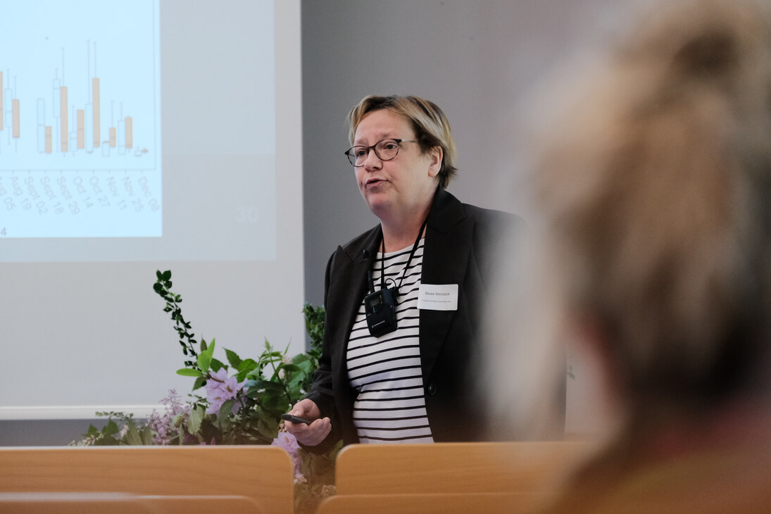 Frau Professor Doktor Beate Michalzik der Friedrich-Schiller-Universität Jena redet vor dem Publikum. Im Hintegrund befindet sich die Leinwand.